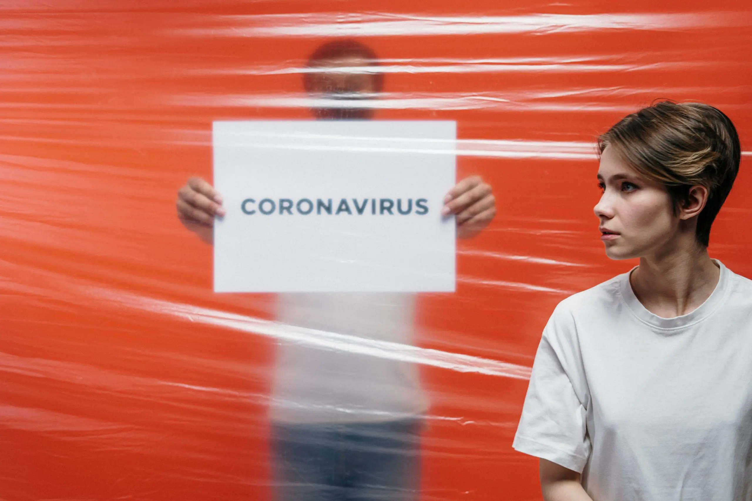 man in white shirt holding a sign of coronavirus 3952188 scaled 1